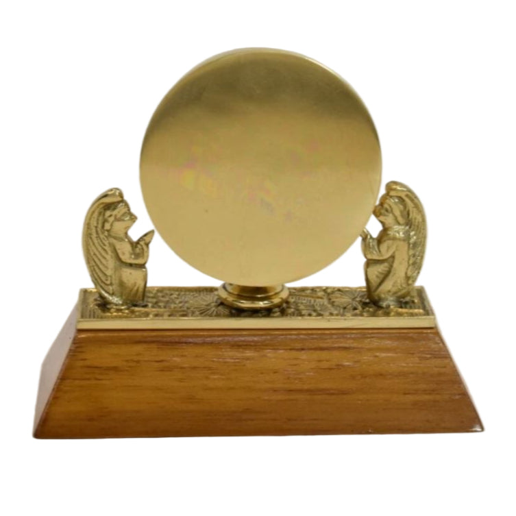 Small Brass angel reliquary on a light wood base. Back side shown