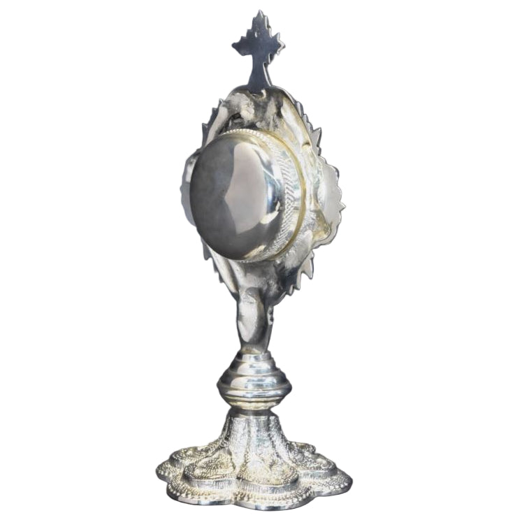 Silver plated French style reliquary with a round relic compartment and a glass front. Side view.