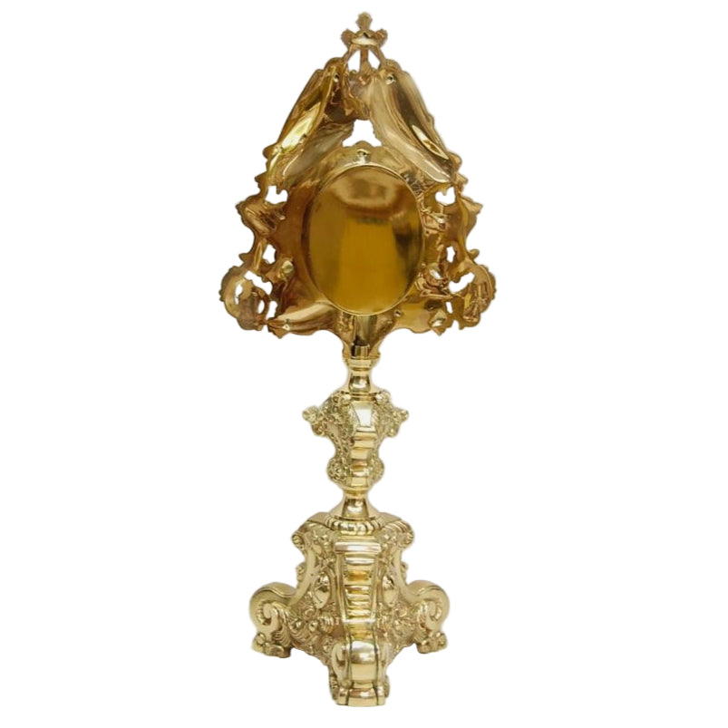 Large Ornate polished brass and lacquered reliquary. 2 Angels perched on top holding the cross. Baroque style base. Glass on front with an oval shaped relic compartment. BACK VIEW