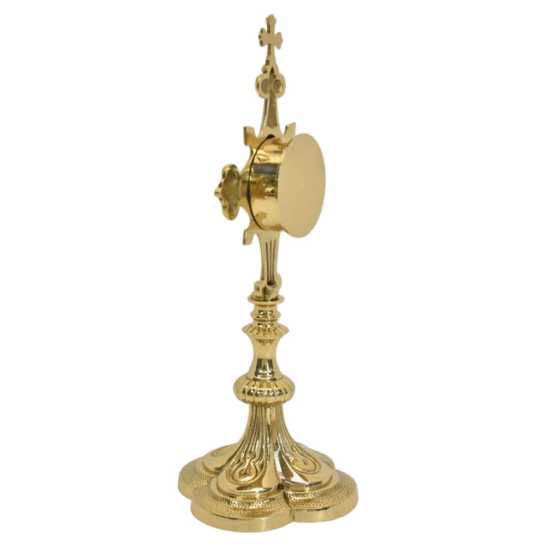 Ornate quatrefoil shaped reliquary. Polished brass and lacquered. Floral shaped glass opening with removable back door.