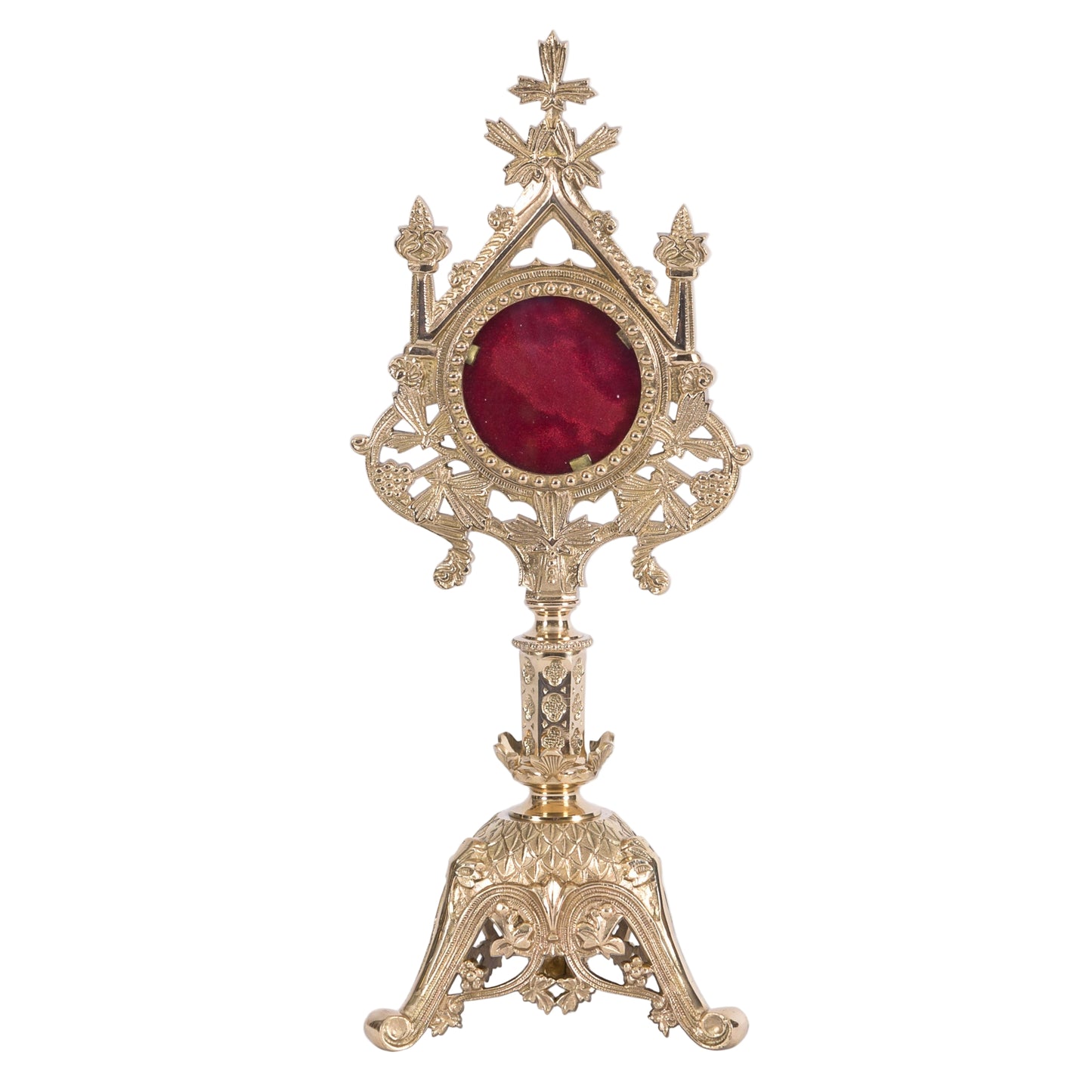 A polished brass and lacquered French style reliquary with a large round front glass and a relic compartment, displayed on a triangular base.