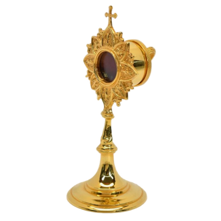 Gold plated brass veneration reliquary with a round glass relic compartment at the top. Handle on the back for easy veneration use. All gold plated over brass. 
SIDE ANGLE VIEW