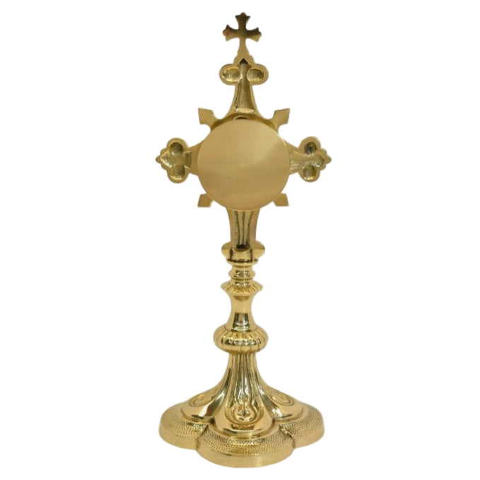 Ornate quatrefoil shaped reliquary. Polished brass and lacquered. Floral shaped glass opening with removable back door. 
