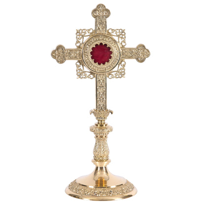 Ornate cross shaped brass reliquary with French style filigree. Floral shaped glass window on front and removable back door. 