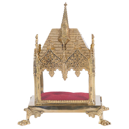 A traditional French style brass relic shrine with a clear front glass and red accents, polished and lacquered finish.