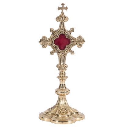 Ornate quatrefoil shaped reliquary. Polished brass and lacquered. Floral shaped glass opening with removable back door. 